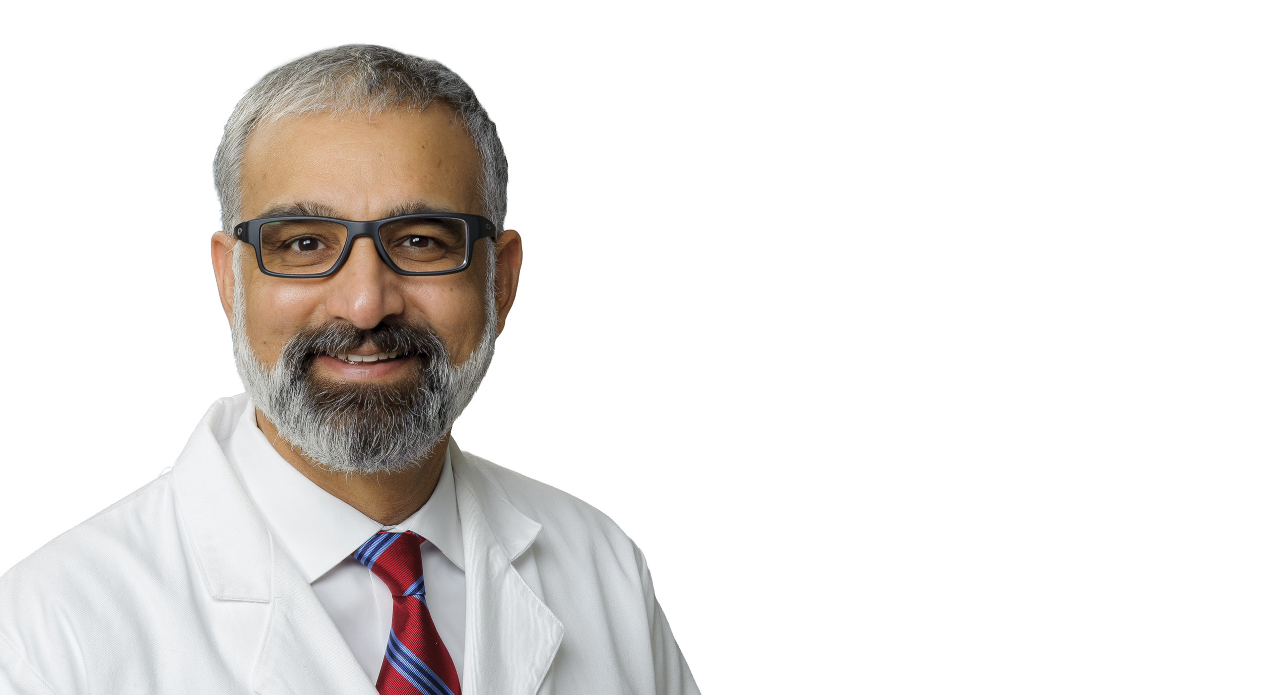 Person wearing a white lab coat and a red‑and‑blue striped tie against a plain white background.